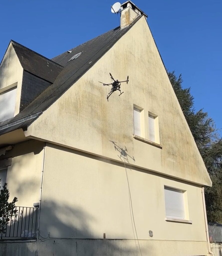 Drone réalisant le nettoyage d'une façade de maison