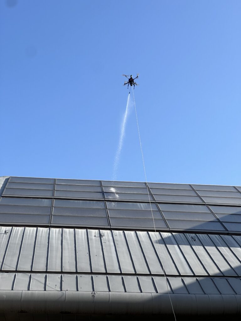 Drone pulvérisant un produit de nettoyage sur des panneaux photovoltaïques