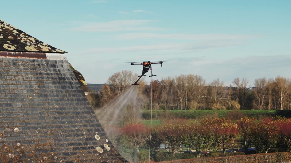 Drone traitant une toiture envahie par les lichens