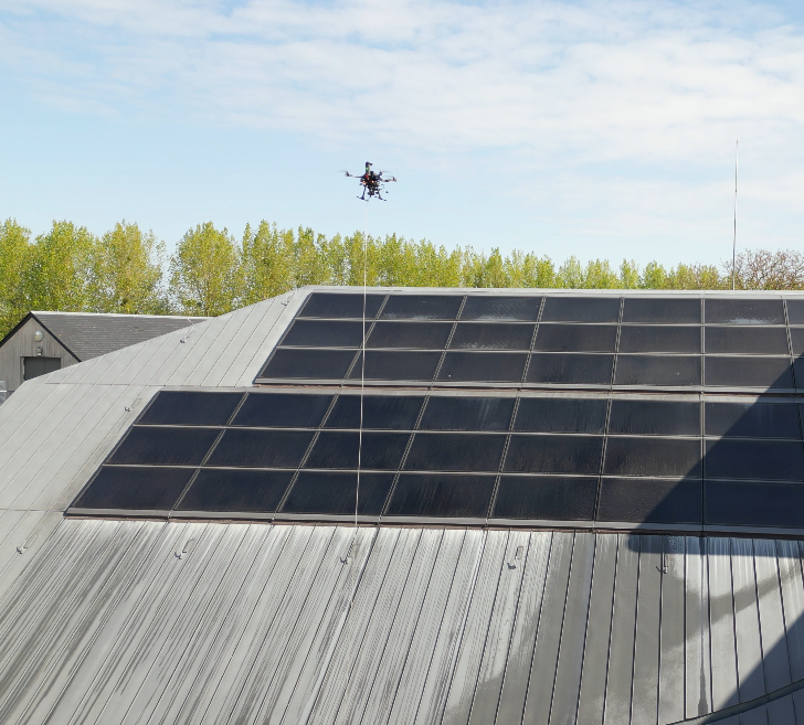 Drone nettoyant des panneaux photovoltaïques installés sur un bâtiment agricole