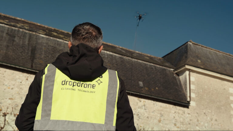 Télépilote Dropdrone supervisant une opération de nettoyage de bâtiment par drone
