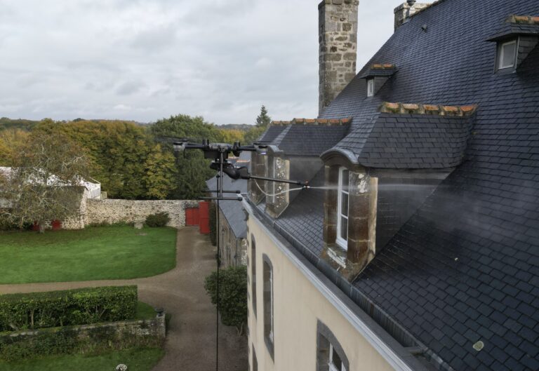 Drone Dropdrone appliquant un traitement hydrofuge sur la toiture en ardoise d’un manoir en Bretagne